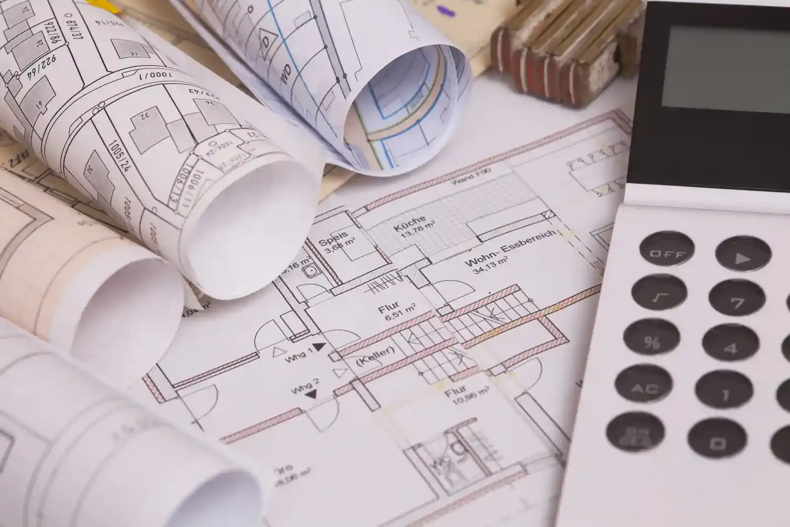 Planos y calculadora sobre una mesa: presupuesto y costo del metro cuadrado de construcción