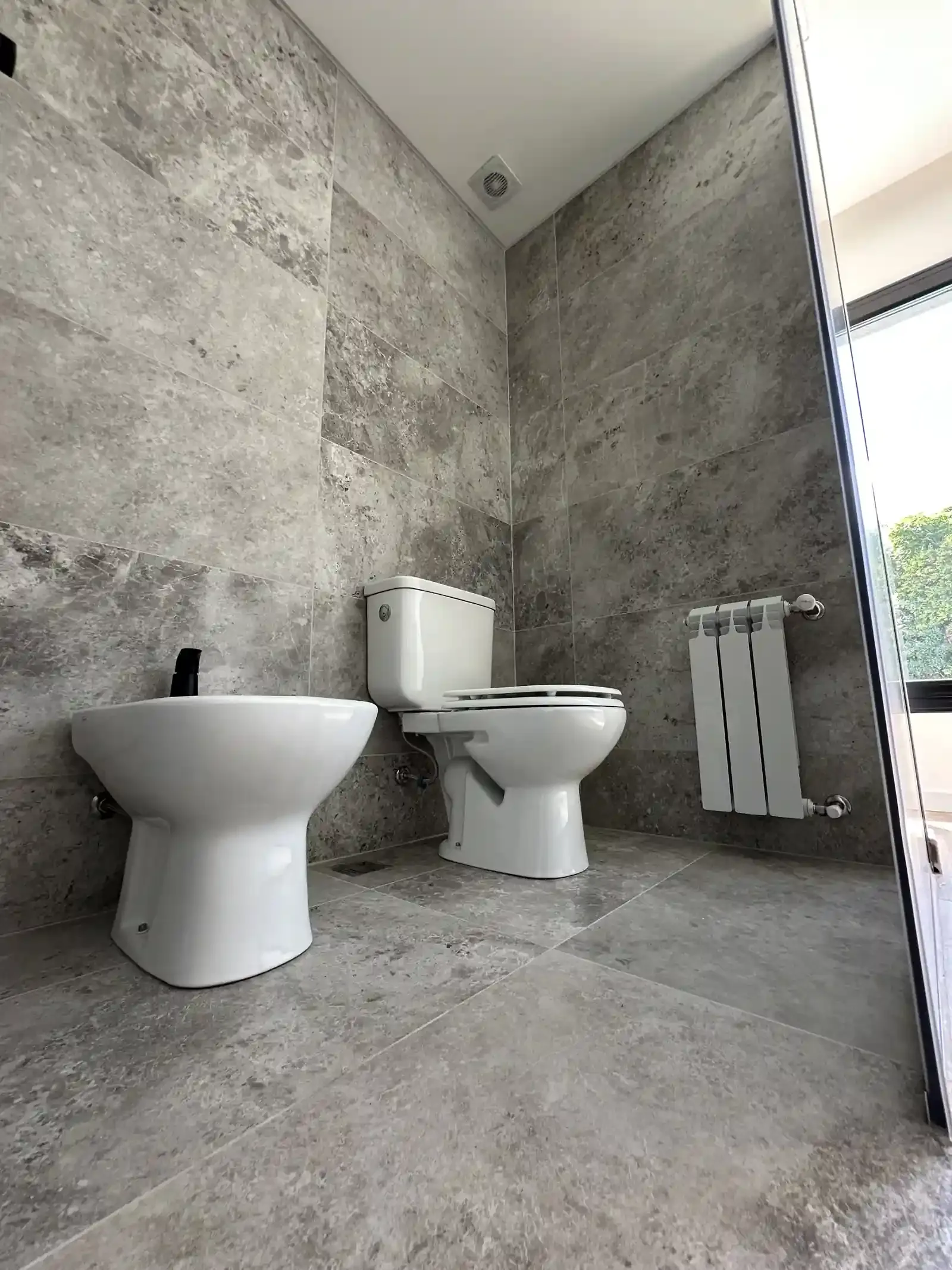 Baño completo de Casa Adrogué en porcelanato símil piedra