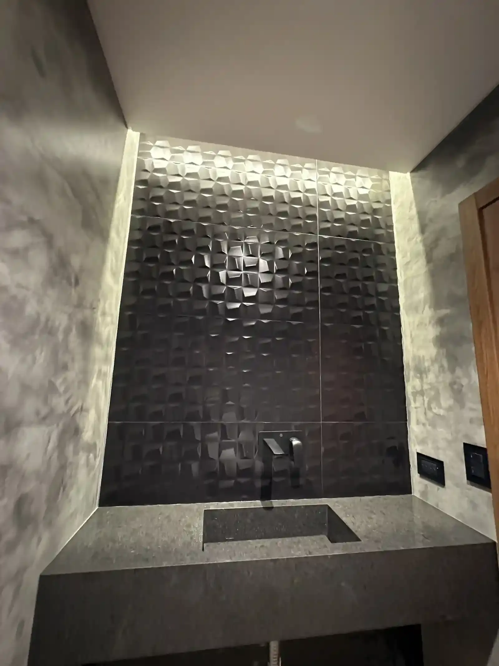 Cerámica negra tridimensional retroiluminada en el toilette de Casa Adrogué